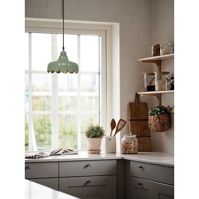 PR Home Pendelleuchte 24cm Fensterleuchte - 25 W, E27 - Eine grüne, gewellte Metallpendelleuchte mit goldener Innenseite hängt in einer hellen Küche über einer Theke am Fenster.