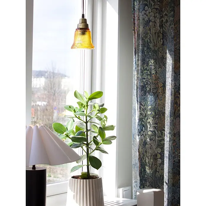 PR Home Pendelleuchte Fensterleuchte - 25 W, E27 - Gelbe gerippte Glas-Pendelleuchte mit Messingfassung, hängt an einem hellen Fenster.