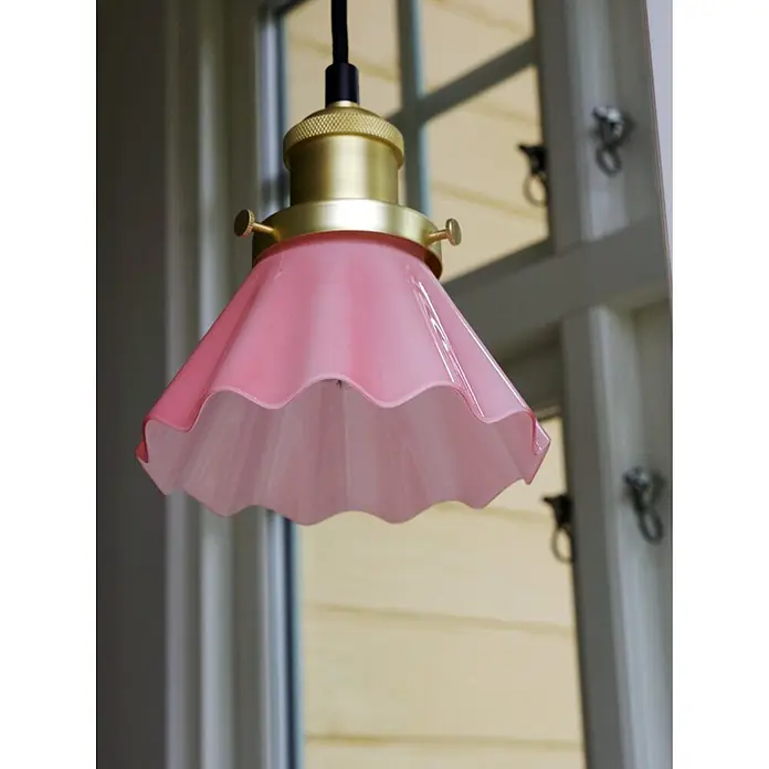 PR Home Pendelleuchte Fensterleuchte - 15 W, L x B x H: 15 x 15 x 16 cm, E27 - Rosa Pendelleuchte aus geriffeltem Glas mit Messingfassung, hängt an einem Fenster.