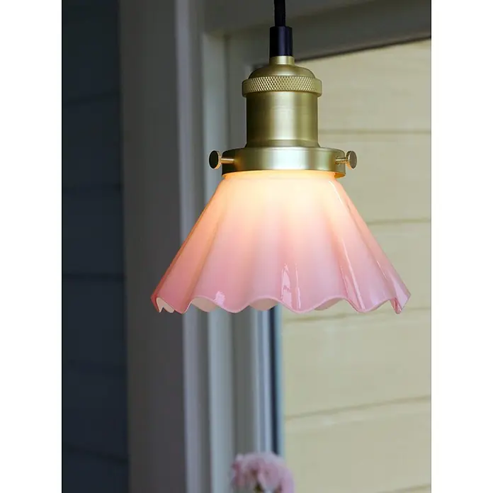 PR Home Pendelleuchte Fensterleuchte - 15 W, L x B x H: 15 x 15 x 16 cm, E27 - Messing-Pendelleuchte mit gerüschtem rosa Glasschirm, beleuchtet in einem Innenraum hängend.