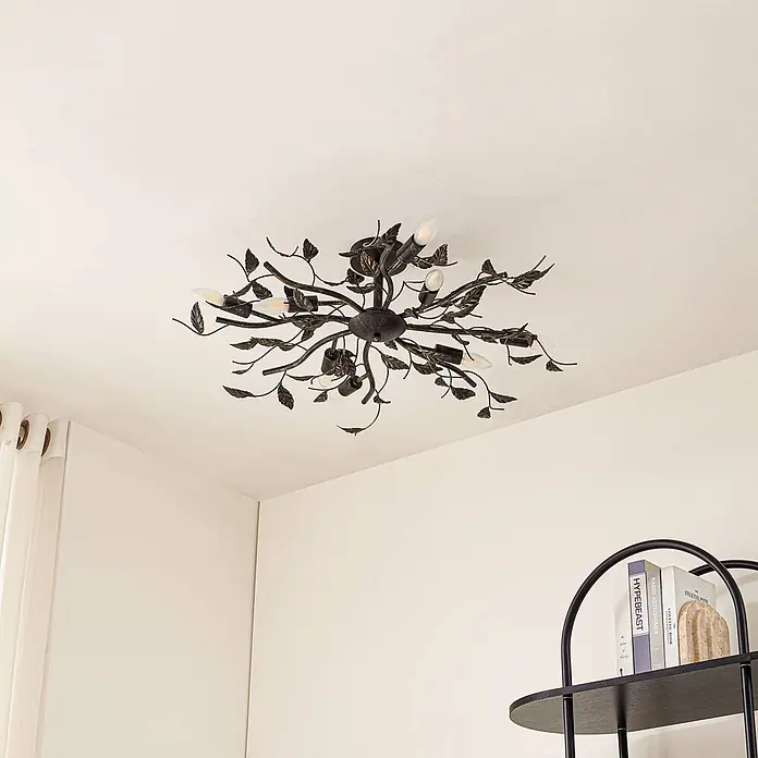 Lindby Deckenleuchte Yos - schwarz, E14 - Dunkle Deckenleuchte aus Metall im Blatt- und Zweigdesign mit mehreren sichtbaren Glühbirnen an einer hellen Decke.
