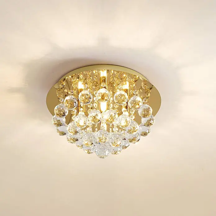 Lindby Deckenleuchte Gillion - messing / gold, klar / transparent, G9 - Goldfarbene Kristall-Deckenleuchte spendet warmes Licht, montiert an einer hellen Decke.