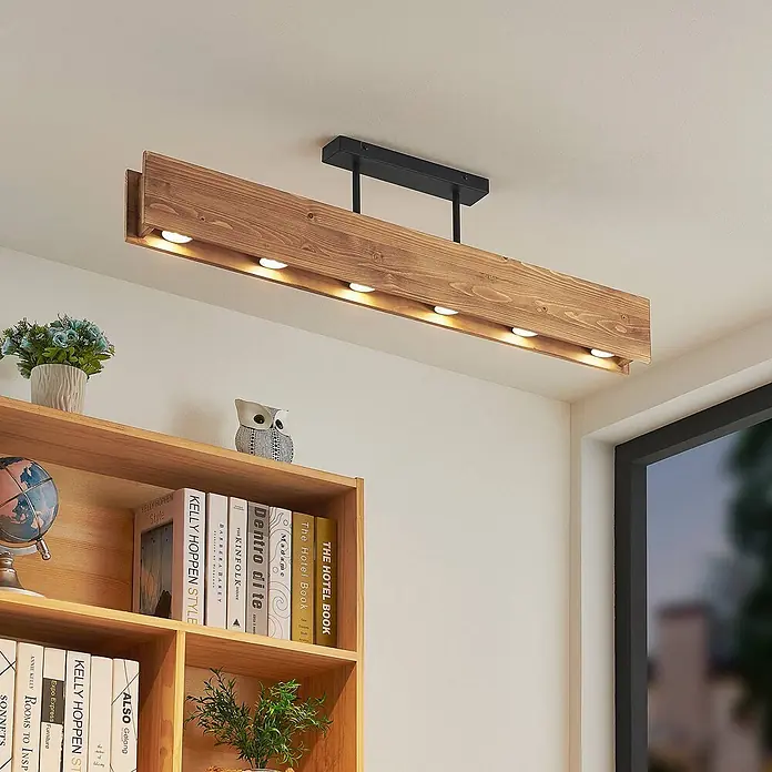 Lindby Deckenleuchte Malwin - L x B x H: 100 x 7 x 25 cm, Holz dunkel, GU10 - Rechteckige Deckenleuchte aus Holz mit mehreren integrierten Spots, an der Decke über einem Bücherregal montiert.