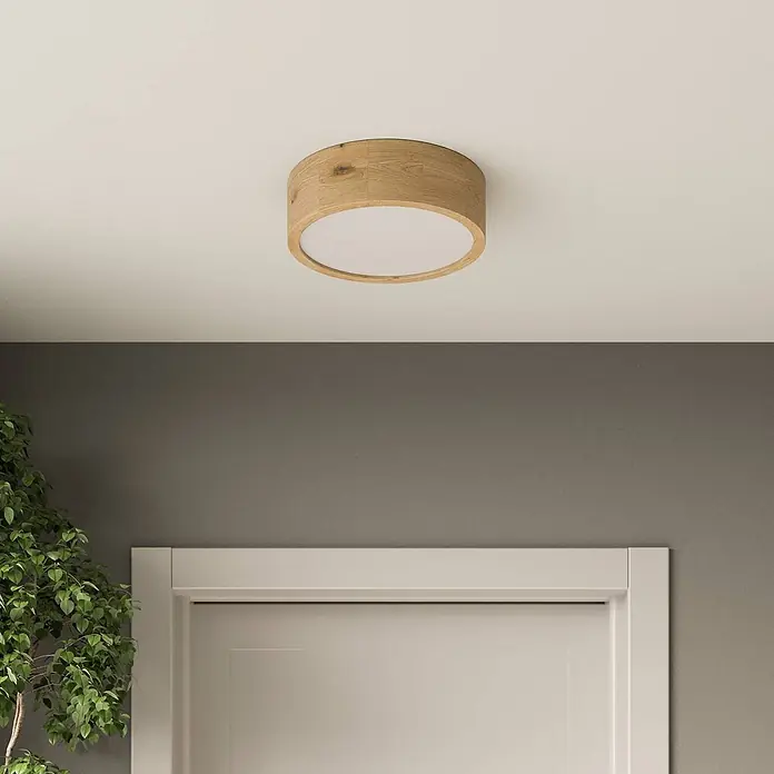Envostar Deckenleuchte Kerio - L x B x H: 27 x 27 x 8 cm, Holz hell, E27 - Runde Deckenleuchte aus Holz mit weißem Diffusor, an einer Decke über einer Tür montiert.