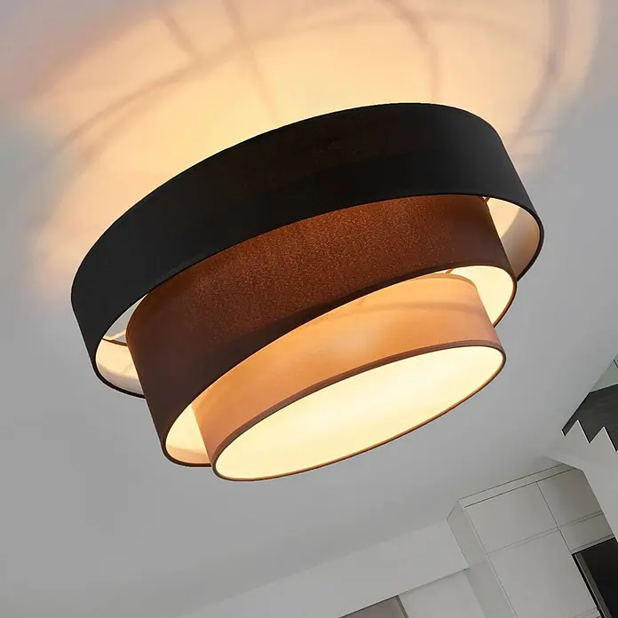 Lindby Deckenleuchte Melia - schwarz, E27 - Mehrstufige Stoff-Deckenleuchte mit schwarzen, braunen und beigen Schirmen, die warmes Licht abstrahlt.