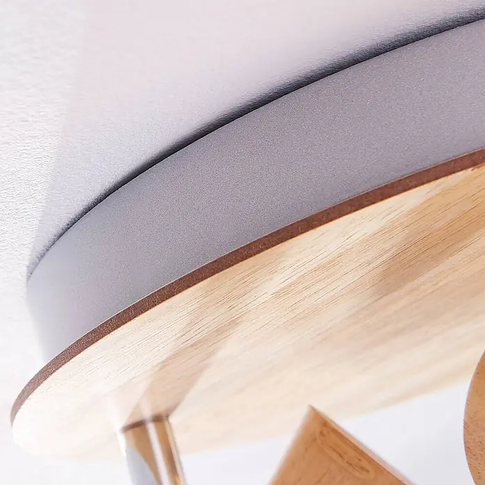 Lindby Deckenleuchte Vivica - Holz hell, E14 - Detailansicht einer Deckenleuchte mit heller Holzplatte, dunkelgrauem Metallband und brauner Kante.