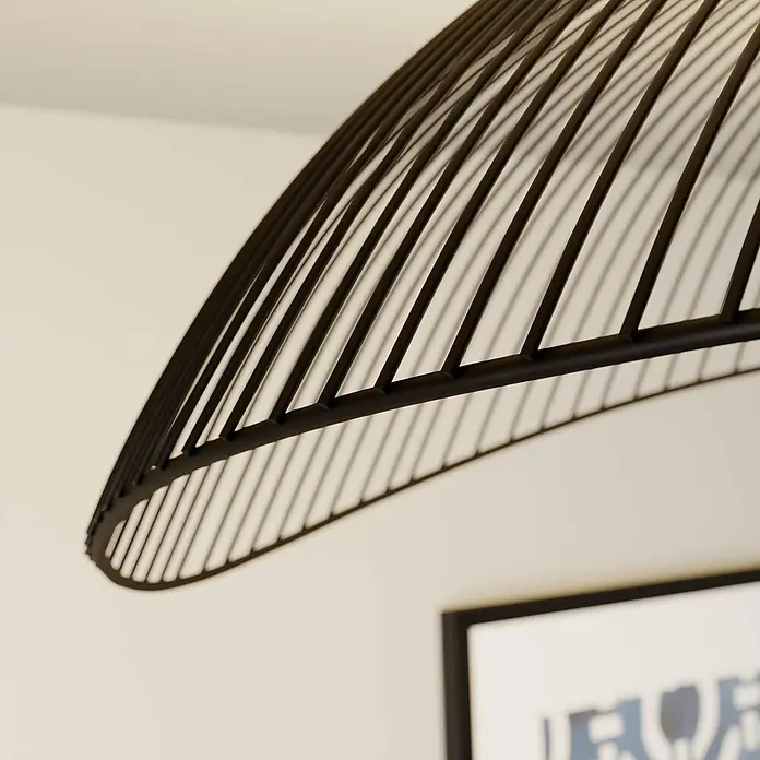 Lindby Deckenleuchte Fabronia - schwarz, schwarz, E27 - Schwarzer Lampenschirm aus Metalllamellen für einen modernen Look, über einem gerahmten Kunstwerk sichtbar.