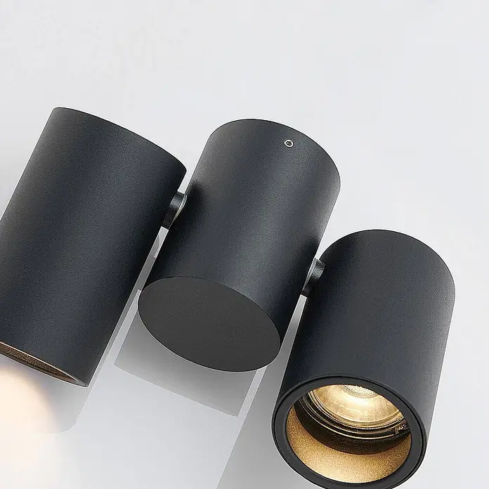 Arcchio Deckenstrahler Gesina - L x B x H: 17,5 x 5,7 x 11,5 cm, schwarz, schwarz, GU10 - Drei schwarze zylindrische Strahler, zwei davon beleuchtet, präsentieren ihr modernes Design und warmes Licht.