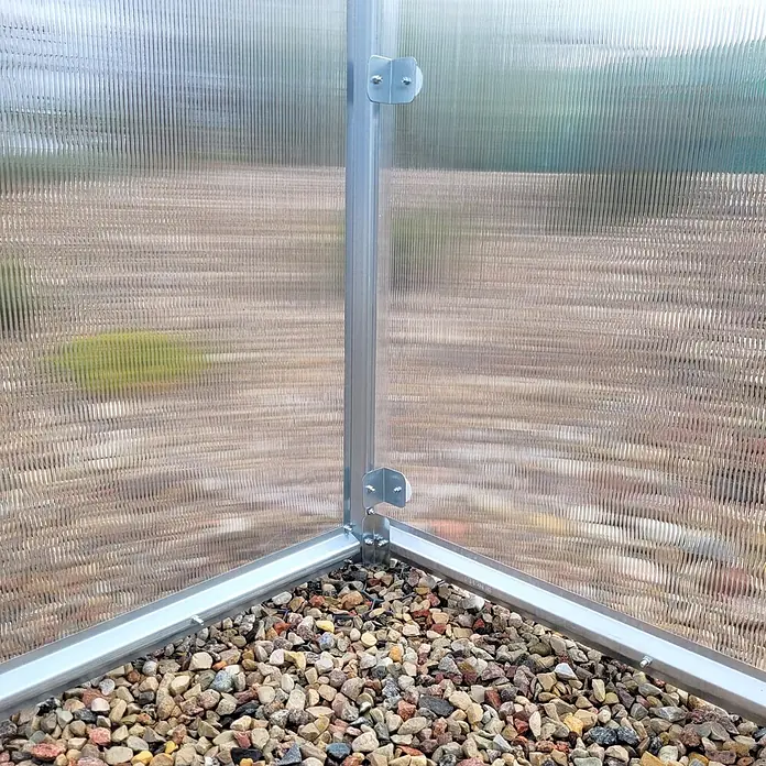 Klasika Greenhouses Gewächshaus Drop Klasika - Außenmaß inkl. Dachüberstand (B x T): 250 x 200 cm, Material Seitenwand: Kunststoff, 4 mm, Silbergrau - Ecke eines Gewächshauses mit geriffelten Polycarbonatplatten, Aluminiumrahmen und Kiesboden.