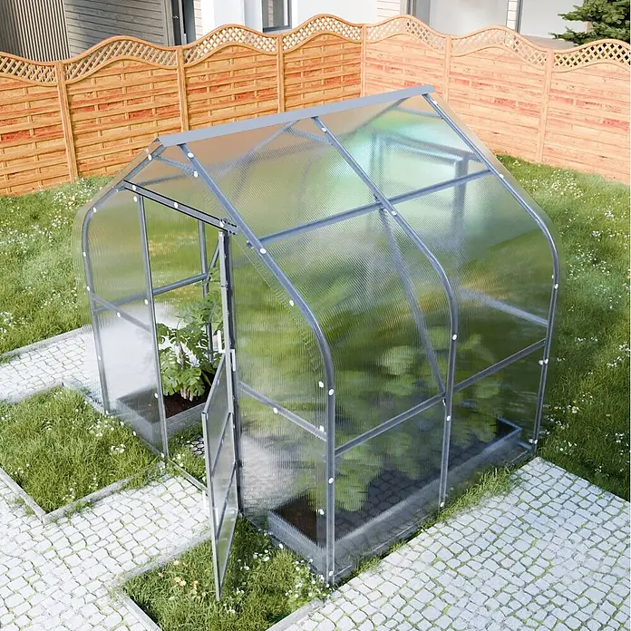 Klasika Greenhouses Gewächshaus Drop Klasika - Außenmaß inkl. Dachüberstand (B x T): 250 x 200 cm, Material Seitenwand: Kunststoff, 4 mm, Silbergrau - Ein Gewächshaus mit grauem Rahmen und transparenten Wellplatten steht im Garten mit Pflanzen und einem gepflasterten Weg.