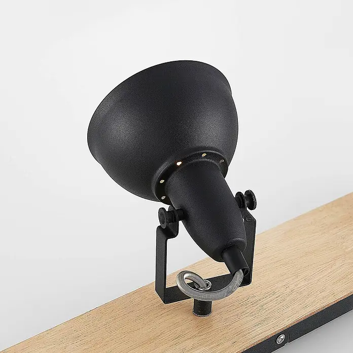 Lindby Deckenstrahler Aylis - Holz dunkel, schwarz, E14 - Schwarzer, texturierter Metallstrahler auf einer hellen Holzleiste, mit kleinen Lichtakzenten um seinen Kopf.