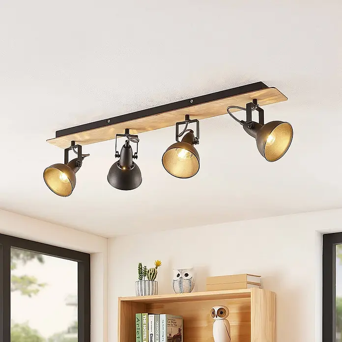 Lindby Deckenstrahler Aylis - Holz dunkel, schwarz, E14 - Deckenleuchte mit vier schwarzen, goldfarbenen Spots auf einem Holzbalken.