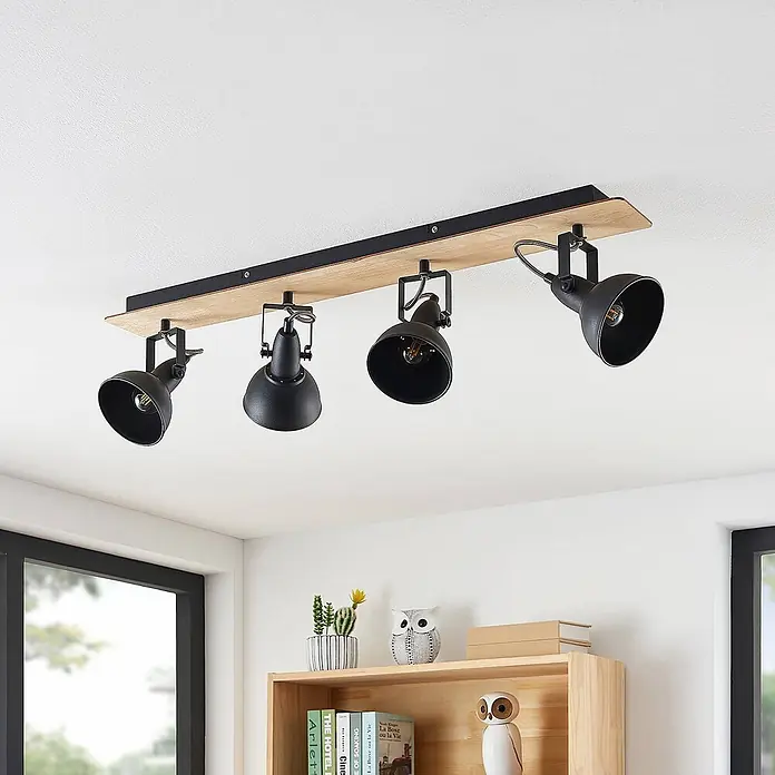 Lindby Deckenstrahler Aylis - Holz dunkel, schwarz, E14 - Schwarze Deckenleuchte mit vier Strahlern auf Holzträger, über einem Regal montiert.