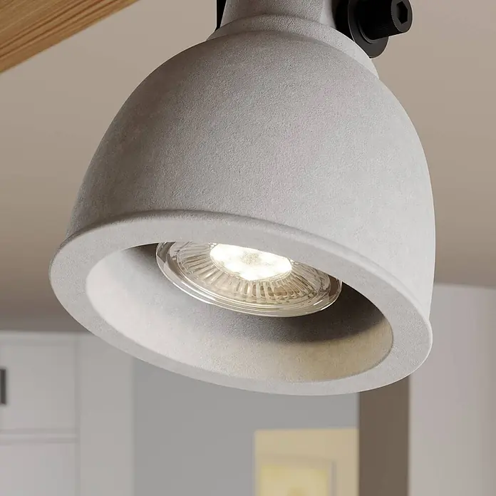 Lindby Deckenstrahler Mitis - Holz dunkel, alu / grau / zink, GU10 - Hellgrauer, texturierter Strahler mit LED-Birne, von einer Schiene in einem Innenraum hängend.