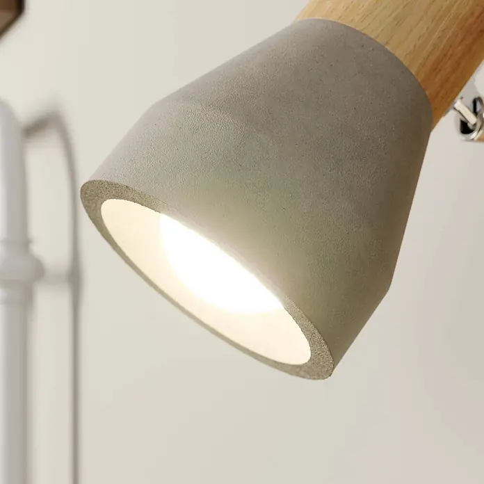 Lindby Deckenstrahler Filiz - Holz hell, alu / grau / zink, E14 - Grauer Spot aus Beton und Holz mit warmem Licht, das aus seiner Öffnung strahlt.