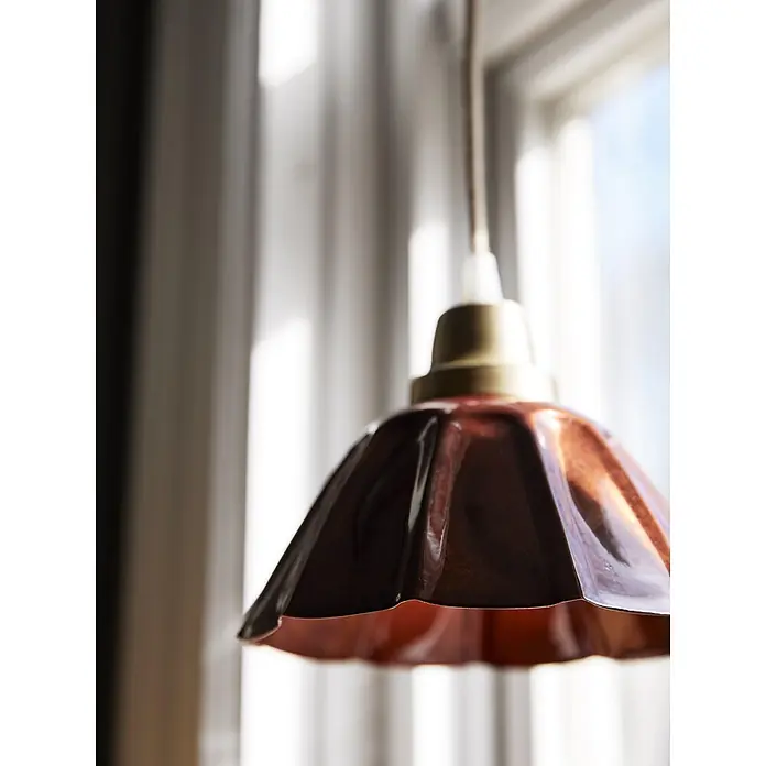 PR Home Pendelleuchte Ester - 15 W, E27 - Geriffelte Bronze-Hängeleuchte mit Messingkappe, vor einem sonnigen Fenster hängend.