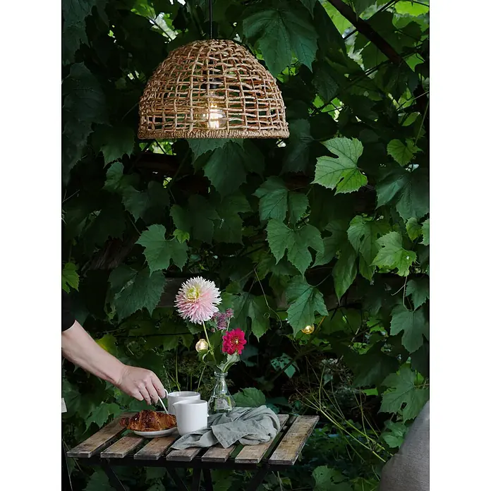 PR Home Pendelleuchte 37cm Outdoor - 40 W, E27 - Hängeleuchte aus Naturfasern über einem Frühstückstisch im Freien, die eine gemütliche Atmosphäre schafft.