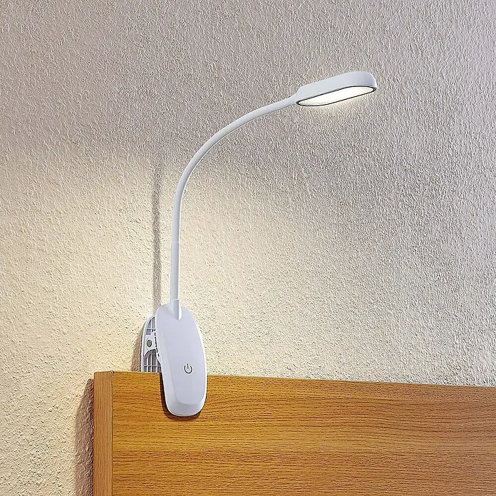 Prios Klemmleuchte Najari - Farbe Gehäuse: weiß / opal - Weiße Klemm-LED-Lampe mit flexiblem Schwanenhals, an einem Holzkopfteil befestigt und eine Wand beleuchtend.