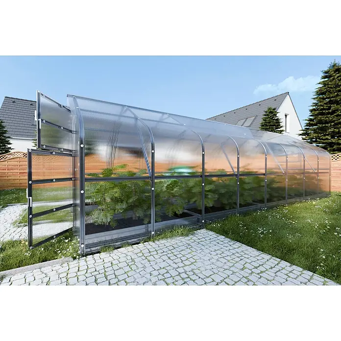 Klasika Greenhouses Gewächshaus Drop Klasika - Außenmaß inkl. Dachüberstand (B x T): 250 x 800 cm, Material Seitenwand: Kunststoff, 4 mm, Silbergrau - Großes Tunneltreibhaus mit transparenten Wellplatten und dunklem Metallrahmen, mit Pflanzen im Garten neben einem gepflasterten Weg.