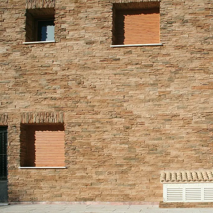Revestimiento de piedra Petra Mineral - Cantidad total: 4 pzs., Mineral - Fachada de un edificio con contraventanas de piedra que aportan un aspecto robusto y natural al edificio.