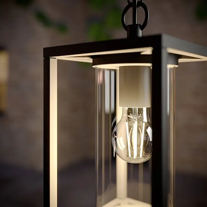 Lucande Außenwand- & Deckenleuchte Ferda - schwarz, schwarz, IP44 - Nahaufnahme einer beleuchteten schwarzen Metall- und Glas-Pendelleuchte mit sichtbarer LED-Filamentlampe.