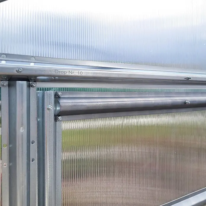 Klasika Greenhouses Gewächshaus Drop Klasika - Außenmaß inkl. Dachüberstand (B x T): 250 x 1.000 cm, Material Seitenwand: Kunststoff, 6 mm, Silbergrau - Verzinkter Metallrahmen und klare Wellplatten eines Gewächshauses, mit "Drop Nr. 10" und sichtbaren Schrauben.
