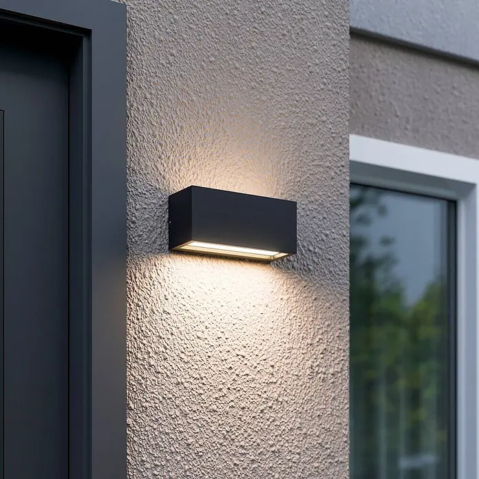 Lucande Außenwandleuchte Bente - schwarz, schwarz, IP54 - Schwarze rechteckige Außenwandleuchte an einer strukturierten Fassade, die Licht nach oben und unten wirft.