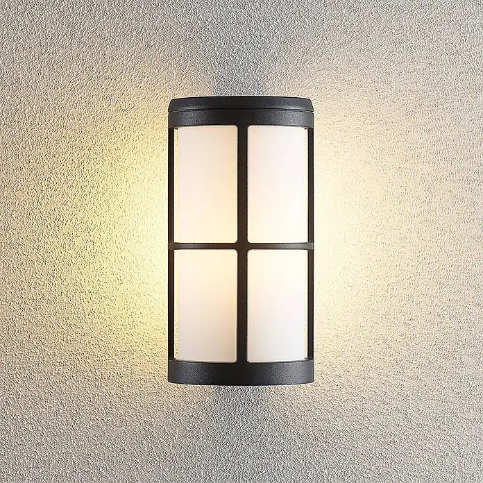 Lucande Außenwandleuchte Kelini - 15 x 12 x 23 cm, schwarz, schwarz, IP54 - Schwarze, rechteckige Außenwandleuchte mit vier mattierten Feldern, die warmes Licht auf eine strukturierte Wand wirft.