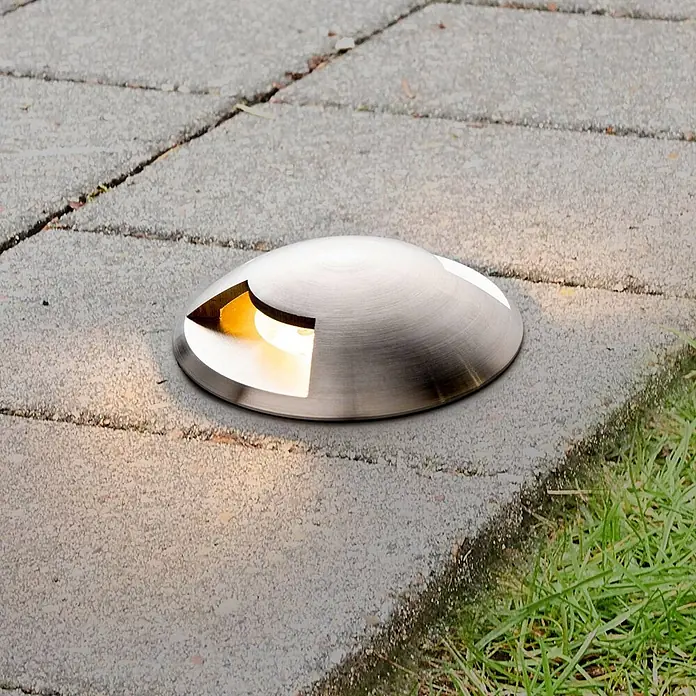 Lucande LED-Gartenstrahler Helene - 3.000 K, 8,8 x 8,8 x 9,5 cm - Bodenleuchte aus gebürstetem Metall mit warmem Licht, in einem gepflasterten Außenweg eingelassen.