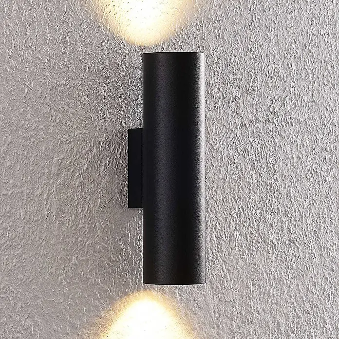 Arcchio Wandleuchte Brinja - L x B x H: 7,2 x 6 x 22,5 cm, schwarz, schwarz, GU10 - Schwarze zylindrische Up-Down-Wandleuchte an einer strukturierten Wand, die warmes Licht nach oben und unten abgibt.