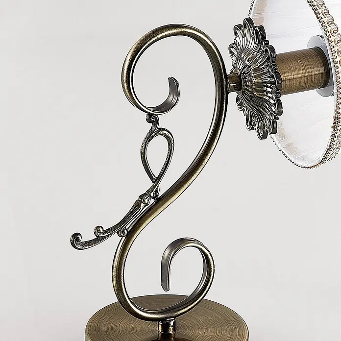 Lindby Wandleuchte Finnick - bronze / altmessing, weiß / opal, E14 - Verzierte Lampe aus Antikmessing mit Schnörkeln und einem weißen plissierten Stofflampenschirm mit dekorativer Goldborte.