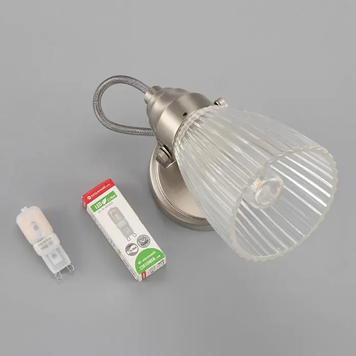 Lindby Wandleuchte Kara - L x B x H: 14 x 9 x 21 cm, alu / grau / zink, G9 - Wandleuchte aus gebürstetem Metall mit geripptem Glasschirm, einer G9 LED-Birne und ihrer Verpackung.