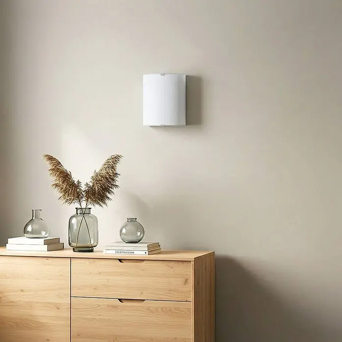 Lindby Wandleuchte Phil - weiß / opal, E27 - Weiße Wandleuchte, montiert an einer hellen Wand.