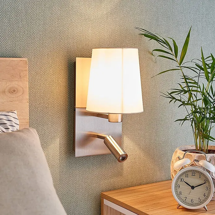 Lindby Wandleuchte Aiden - L x B x H: 17,6 x 14 x 30,8 cm, alu / grau / zink, weiß / opal, E14 - Gebürstete Metall-Wandleuchte mit weißem Stoffschirm und verstellbarer LED-Leselampe, über einem Nachttisch montiert.