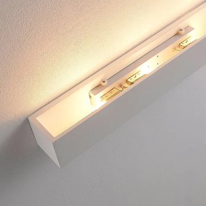 Lindby Wandleuchte Santino - weiß / opal, G9 - Weiße rechteckige Wandleuchte, die warmes Licht nach oben und unten auf eine strukturierte Wand wirft.