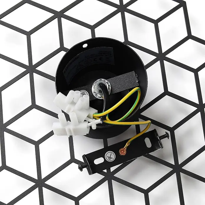 Lucande Wandleuchte Alexaru - L x B x H: 8,8 x 36,7 x 30,1 cm, schwarz, schwarz, E27 - Nahaufnahme der Verdrahtung einer schwarzen Leuchte, mit Klemmenblock, Erdleiter und Montagebügel auf geometrischem Muster.