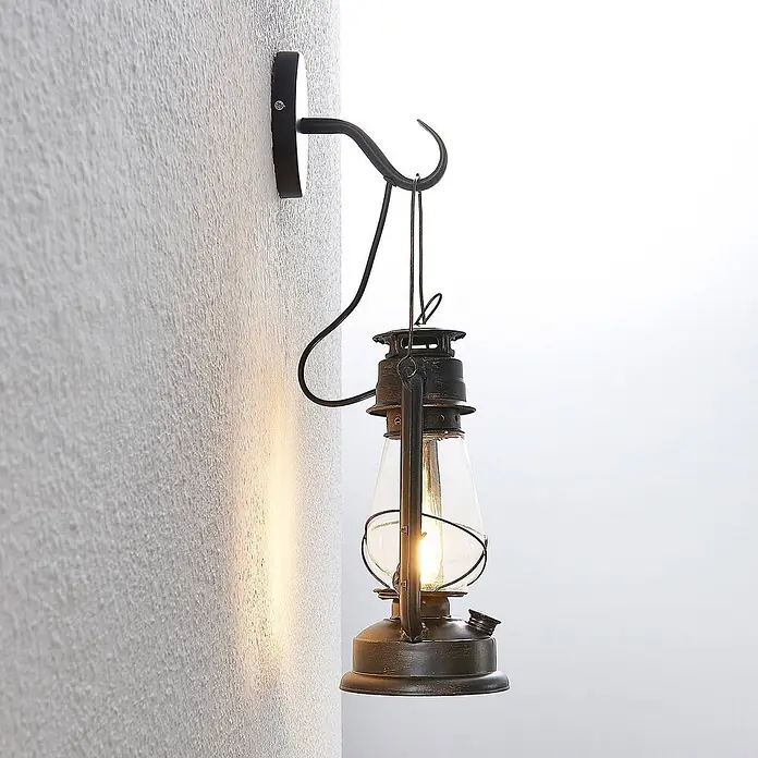 Lindby Wandleuchte Raisa - braun / rost, E14 - Rustikale Wandleuchte im Laternen-Stil aus dunklem Metall mit sichtbarer Glühbirne, an einem geschwungenen Haken.