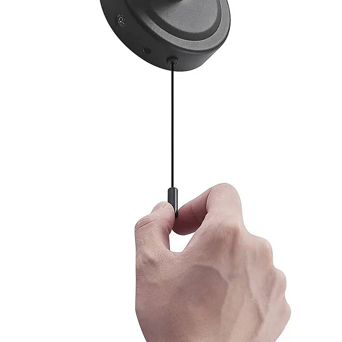 Lindby Wandleuchte Zaniba - L x B x H: 12,4 x 10 x 17,7 cm, schwarz, G9 - Hand zieht eine schwarze Zugkette von einer dunkelgrauen Deckenleuchte.