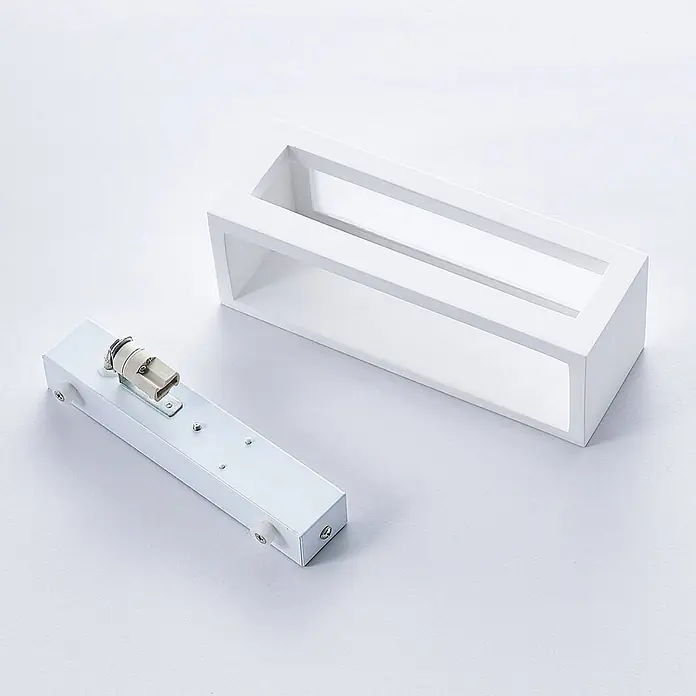 Lindby Wandleuchte Tjada - L x B x H: 7,5 x 21,8 x 7,5 cm, weiß / opal, G9 - Weiße, rechteckige Leuchtenkomponenten: ein äußerer Rahmen und ein Innenteil mit Lampenfassung.