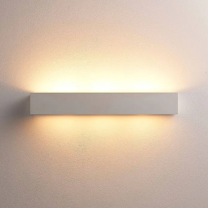 Lindby Wandleuchte Tjada - L x B x H: 7,5 x 50,8 x 7,5 cm, weiß / opal, G9 - Weißes rechteckiges Wandlicht, das warmes Licht nach oben und unten auf eine strukturierte Wand wirft.