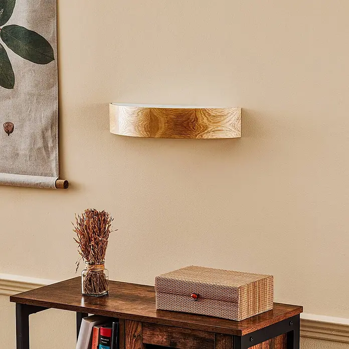 Envostar Wandleuchte Kerio - L x B x H: 11,5 x 40,5 x 8 cm, Holz hell, E27 - Geschwungenes Wandregal aus Holz mit natürlicher Maserung, an einer beigen Wand montiert.