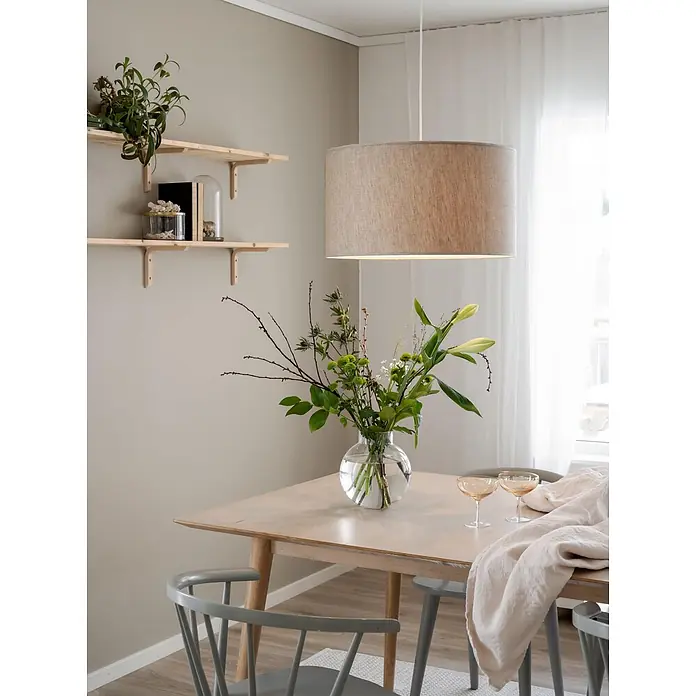 PR Home Pendelleuchte Sara - 15 W, E27 - Heller Essbereich mit hellem Holztisch, grauen Stühlen, Stoffpendelleuchte und Regalen mit Dekoration.