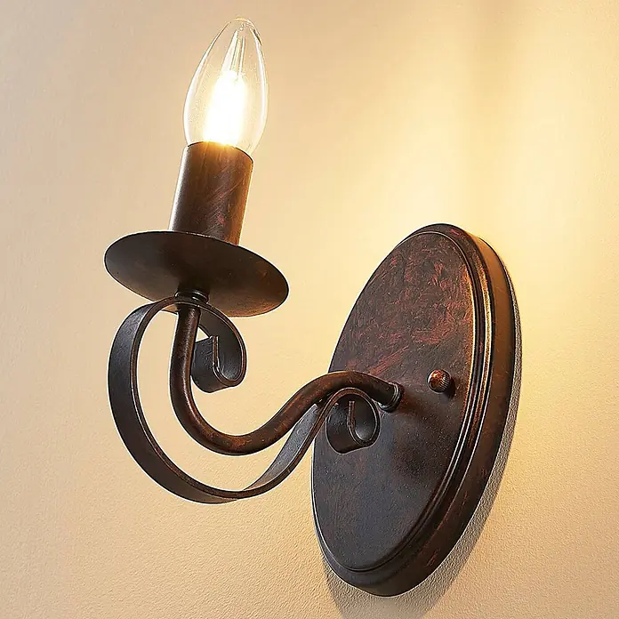 Lucande Wandleuchte Caleb - braun / rost, braun / rost, E14 - Rustikale Wandleuchte aus dunkler Bronze mit Zierschmiedeelementen und einer beleuchteten Kerzenbirne.