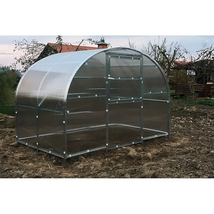 Klasika Greenhouses Gewächshaus Baltic Lt Klasika - Außenmaß inkl. Dachüberstand (B x T): 300 x 200 cm, Material Seitenwand: Kunststoff, 4 mm, Silbergrau - Gewölbtes Polycarbonat-Gewächshaus mit Metallrahmen, auf bearbeitetem Boden in einem Garten, bereit zur Bepflanzung.