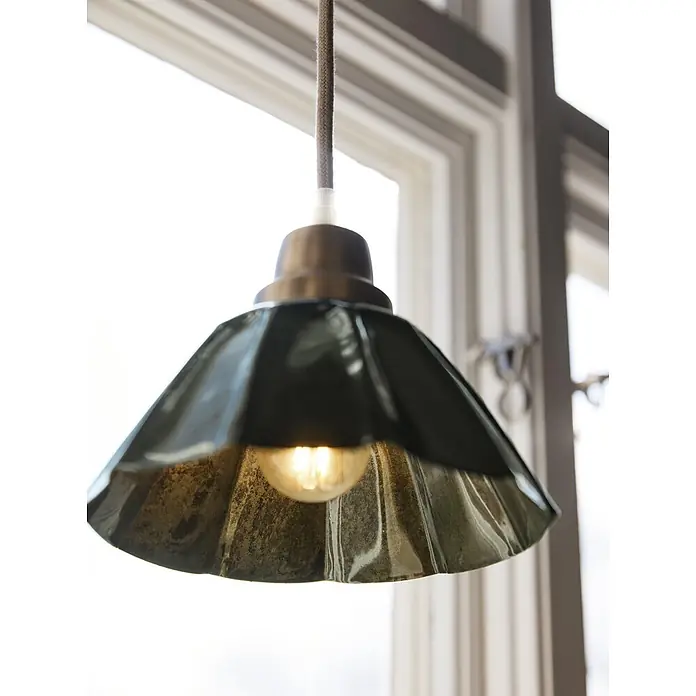 PR Home Pendelleuchte Ester - 15 W, E27 - Dunkelgrüne Pendelleuchte aus Metall mit Messingfassung und geflochtener Kordel, beleuchtet vor einem Fenster.