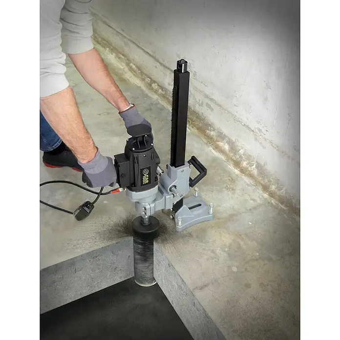 Fartools Taladro perforador de corona CB 2300S - 2.300 W, Diámetro de taladrado máx. en hormigón: 180 mm - Persona taladra un agujero en hormigón con una máquina perforadora de hormigón gris y negra.