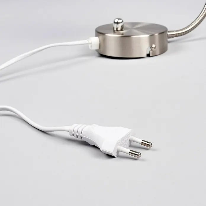 Lindby Wandleuchte Amrei - alu / grau / zink, alu / grau / zink, E14 - Weißes Stromkabel mit europäischem zweipoligem Stecker, angeschlossen an einen gebürsteten Metallsockel.