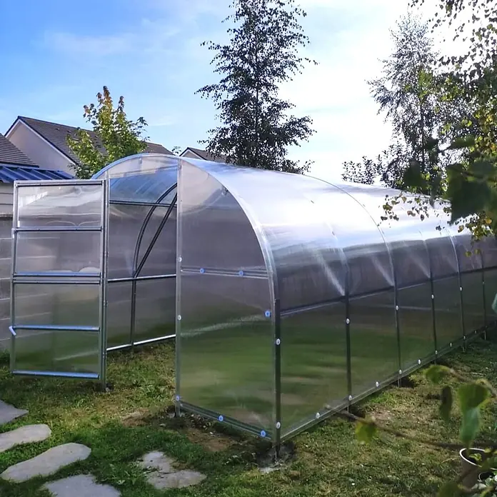 Klasika Greenhouses Gewächshaus Baltic Lt Klasika - Außenmaß inkl. Dachüberstand (B x T): 300 x 1.200 cm, Material Seitenwand: Kunststoff, 4 mm, Silbergrau - Großes, gewölbtes Gewächshaus mit transparenten Paneelen und Metallrahmen im Garten.