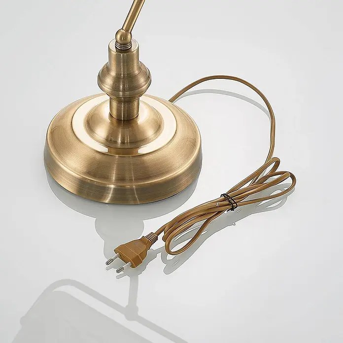 Lindby Tischleuchte Profina - L x B x H: 18,5 x 27,2 x 38,5 cm, bronze / altmessing, weiß / opal, E27 - Sockel einer Lampe aus gebürstetem Messing mit aufgewickeltem braunem Netzkabel und europäischem Zweipolstecker.