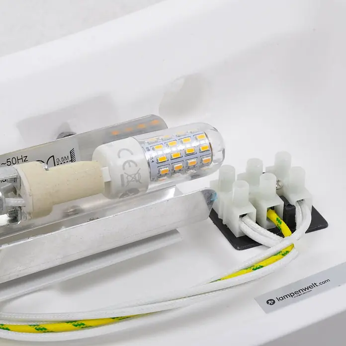 Lindby Wandleuchte Leander - weiß / opal, G9 - Innenansicht einer Leuchte: G9-LED-Leuchtmittel, Keramikfassung und Klemmleiste mit Verkabelung.